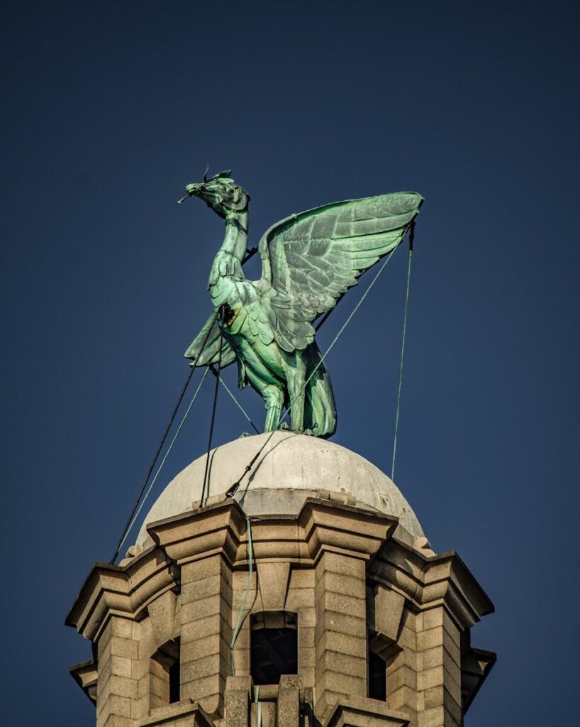 green bird statue above temple